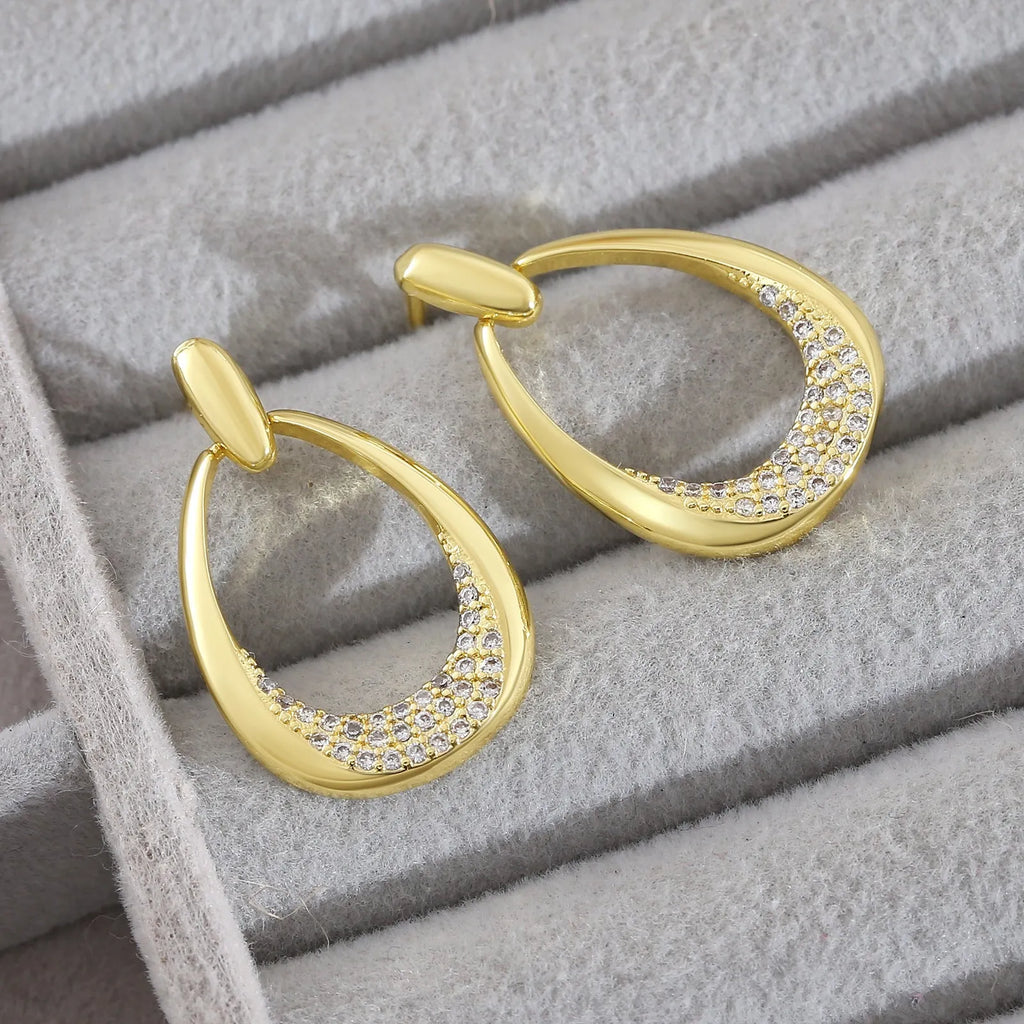 Yellow gold coloured geometric drop earrings for women, showing oval ring design.