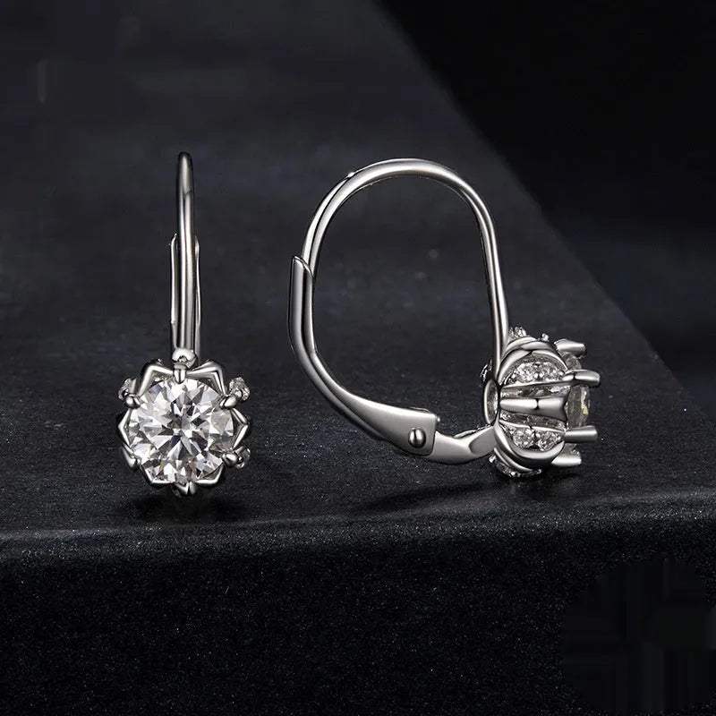 Close-up of a sterling silver flower bud ear clip with a white gold plated finish and a central 0.5 carat moissanite stone.