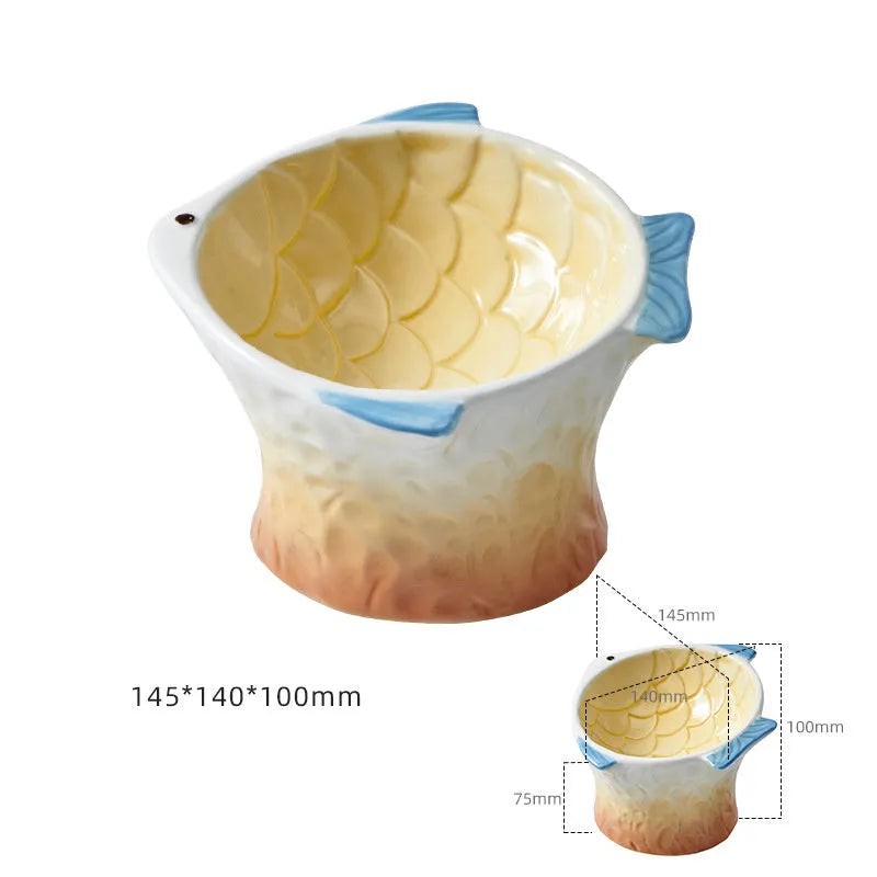 Blue fish-shaped ceramic cat bowl with tilted design on a wooden surface.