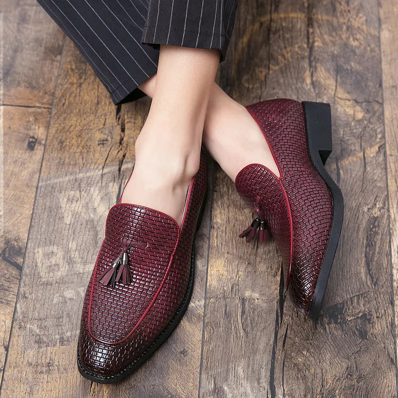 Men's black pointed toe slip-on business shoes with a tassel decoration on the front.