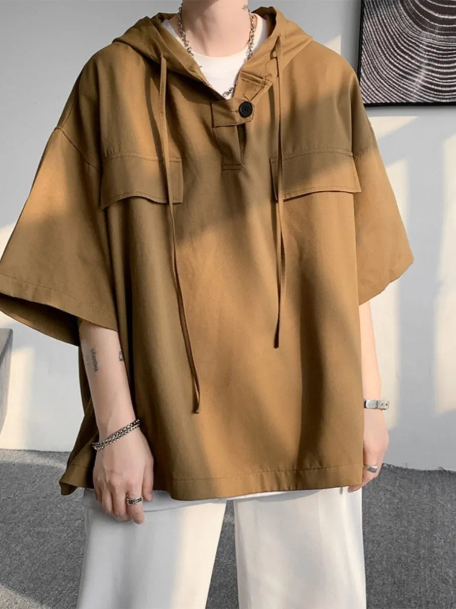 Man wearing a loose-fit black polyester hooded t-shirt with short sleeves.