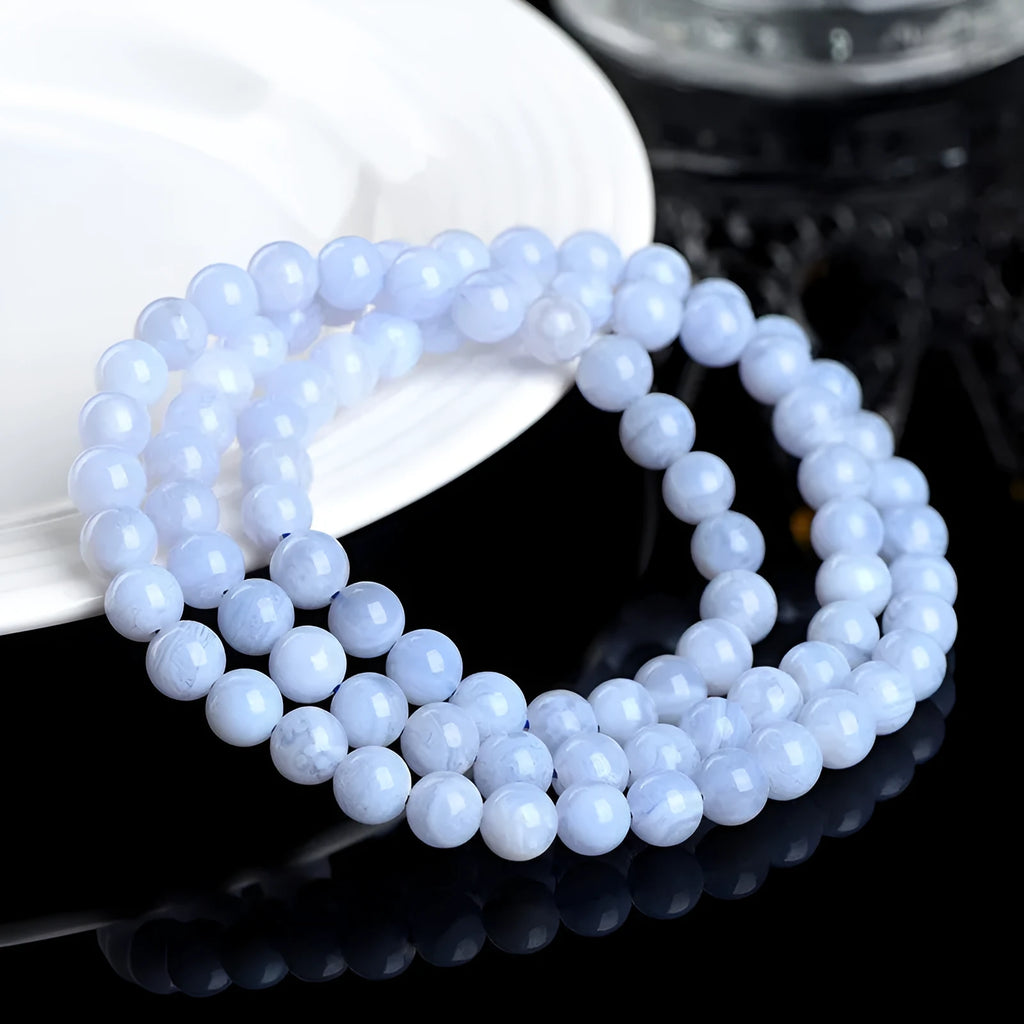 Close-up of a blue agate beaded bracelet with multi-circle pattern and scattered striped beads on a wrist.