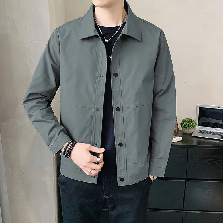 A man wearing a thin, single-layer Korean-style jacket in light grey, suitable for spring or autumn.