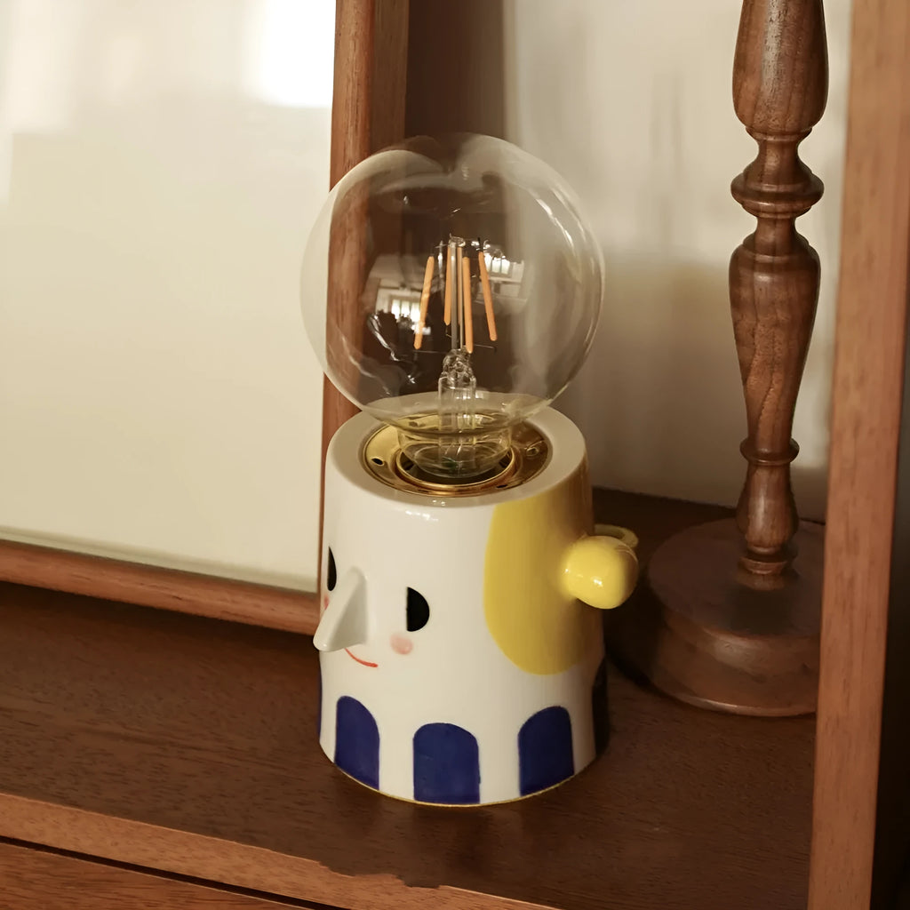 Handmade ceramic table lamp with ball headlight shade on wooden surface