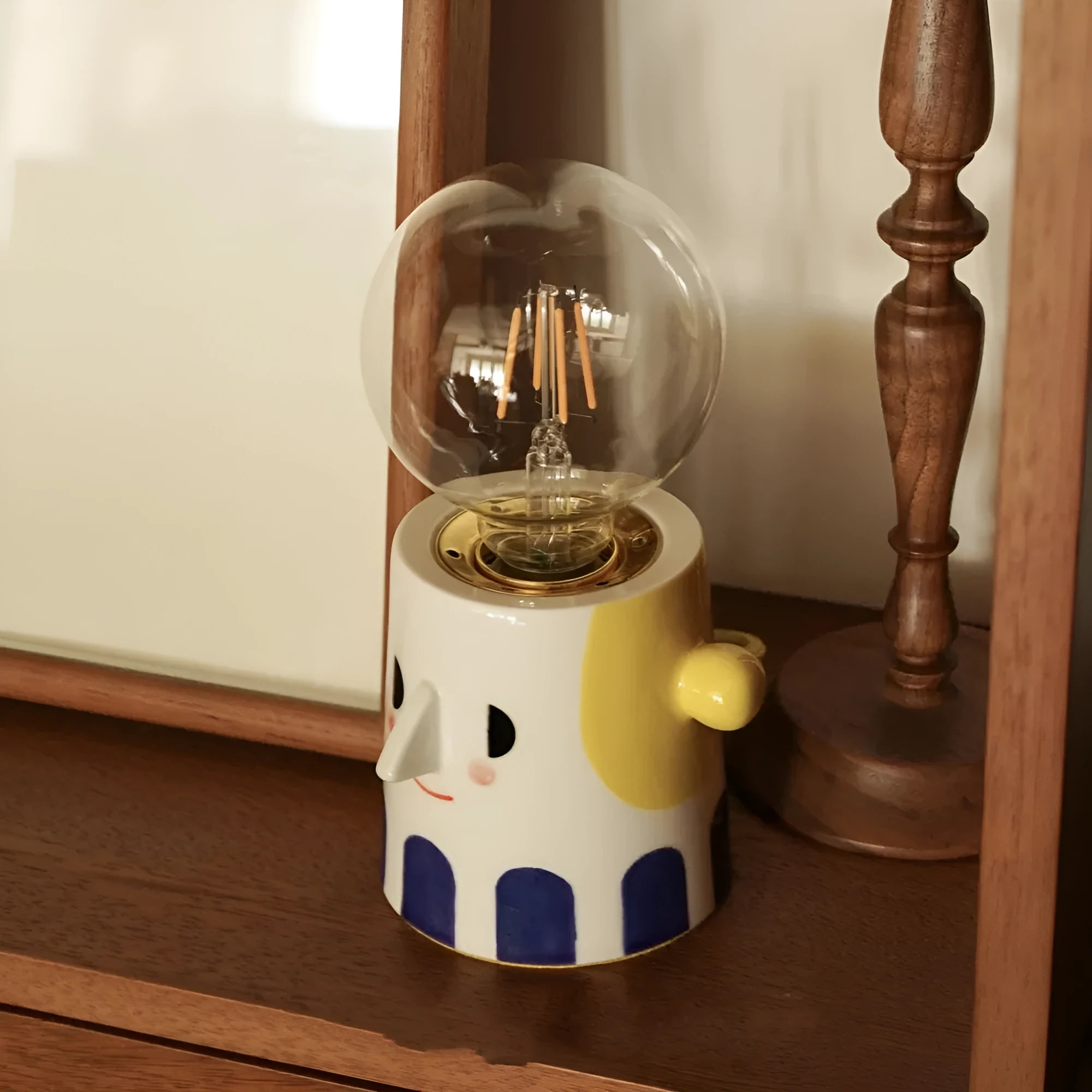 Handmade ceramic table lamp with ball headlight shade on wooden surface