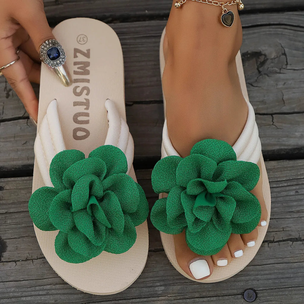 Plus size solid colour flip flop slippers with a flower detail on the upper, shown in beige.