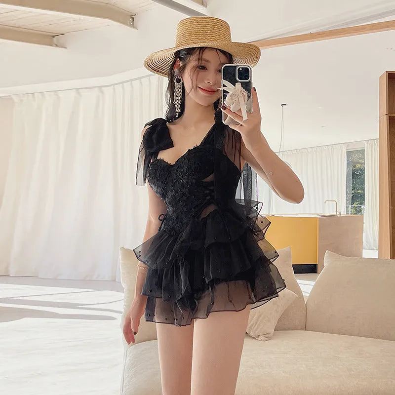Black conservative one-piece swimsuit with gathered chest detailing and sleeveless design