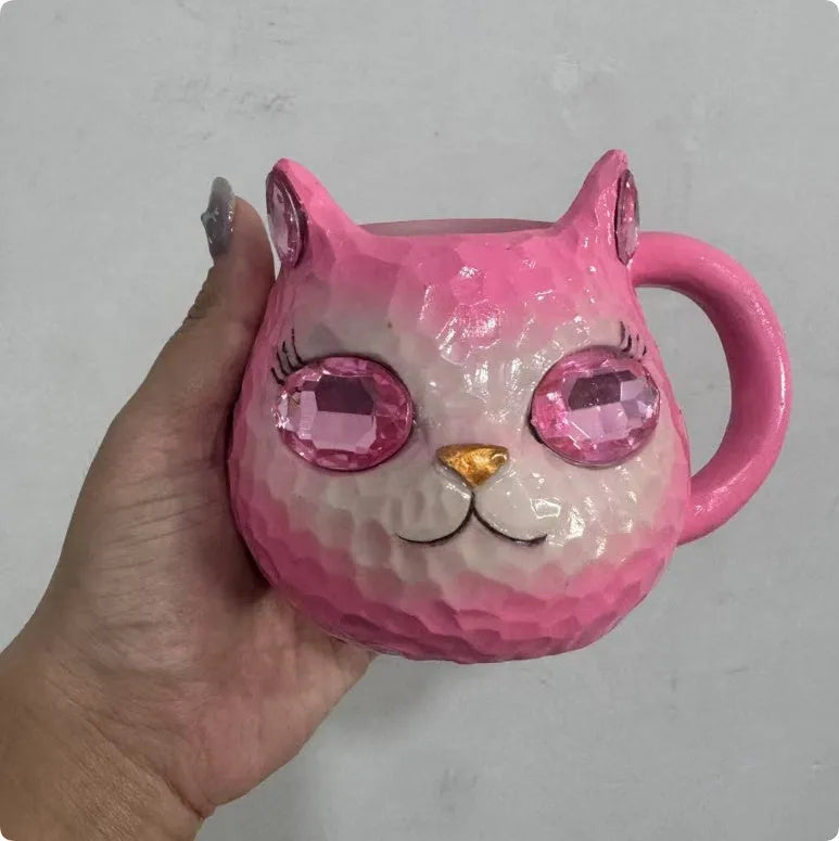 Purple, green, blue, and pink resin cat cup crystal earth craft ornament on display.
