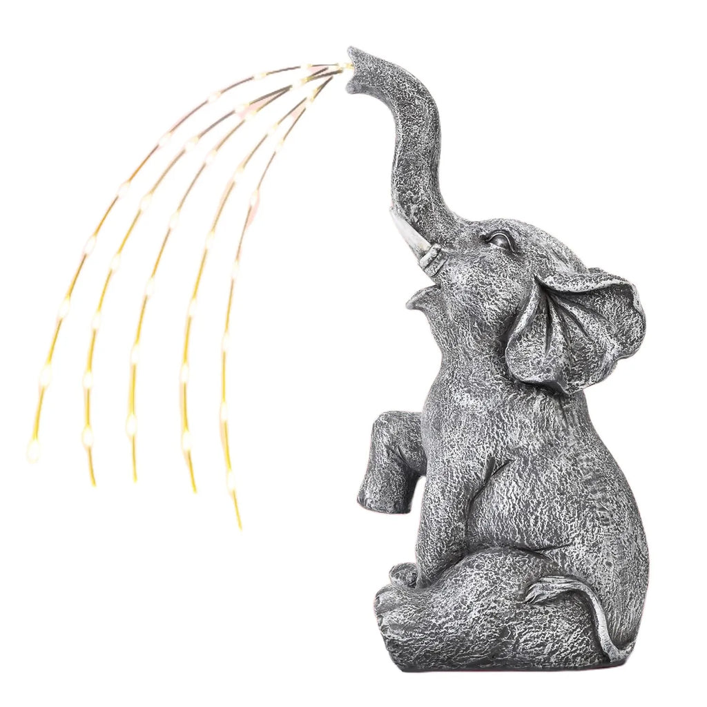 Grey resin elephant garden statue with white LED string lights wrapped around its body.