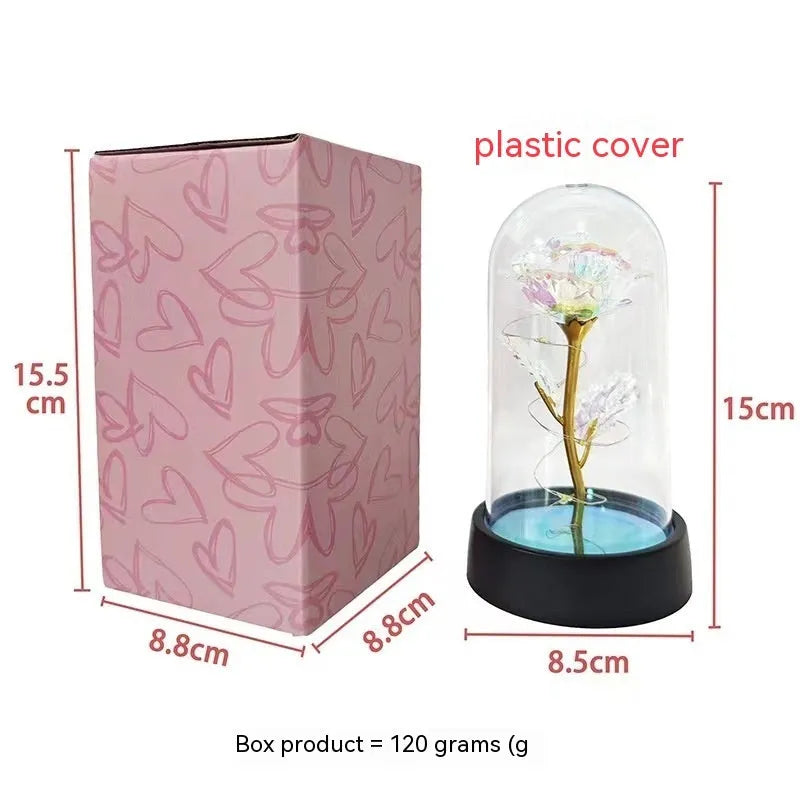 Small glass cover night lamp with plastic flower decoration showing warm golden light illumination