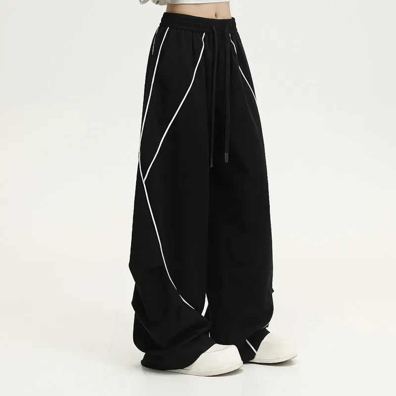 Black striped hip hop trousers with wide-leg pleated design showing mid-waist styling