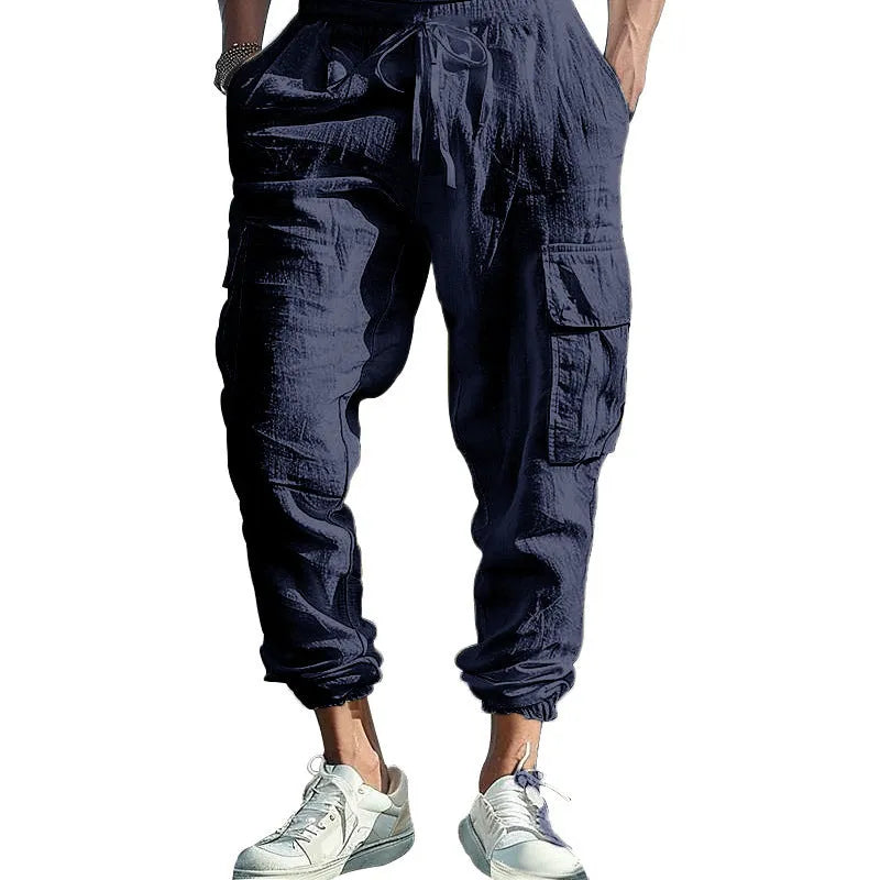 Men's loose-fit linen casual trousers with ankle-tied cuffs and multiple pockets in a solid colour.