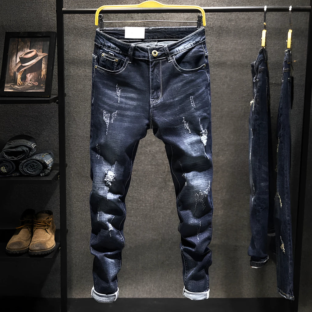 Men's dark blue skinny jeans with a slim fit and mid waist, laid flat.