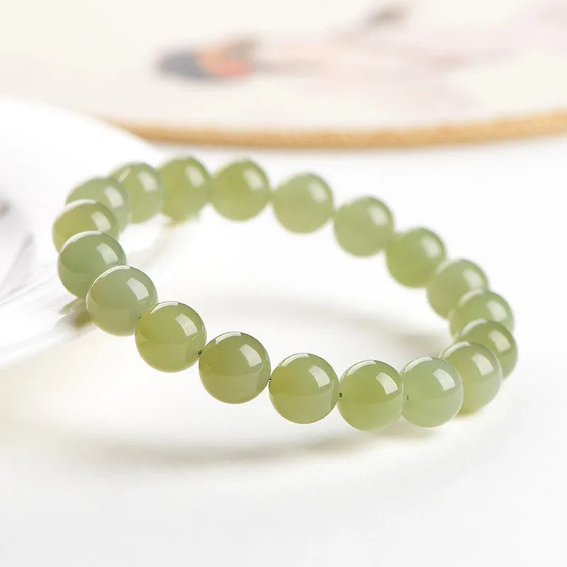 Polished Hetian jade ball bracelet on wrist, showing clear beads.
