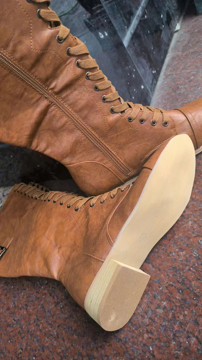 Women's brown ankle boots with a front cross strap and buckle fastening, shown on a white background.