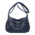 Large black women's shoulder bag with multiple compartments and luggage-inspired styling