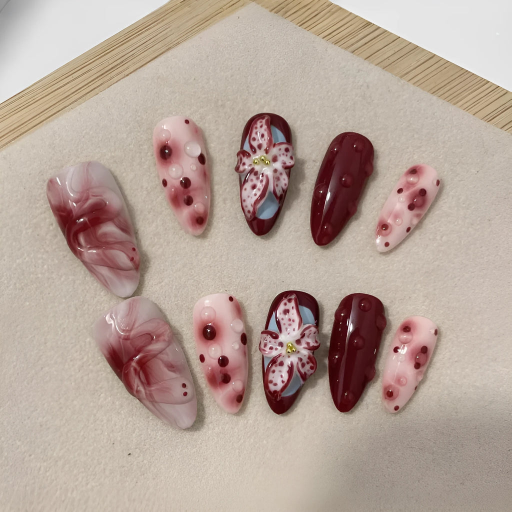 Set of almond-shaped false nails with hand-painted 3D rose and starry sky designs, showing ultra-thin edges.