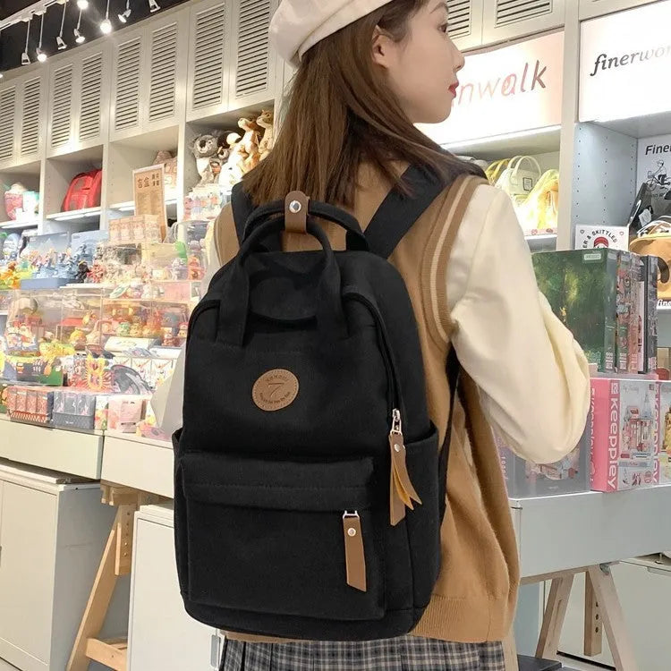 Black Oxford cloth fashion backpack with curved shoulder straps and retro sewing thread details