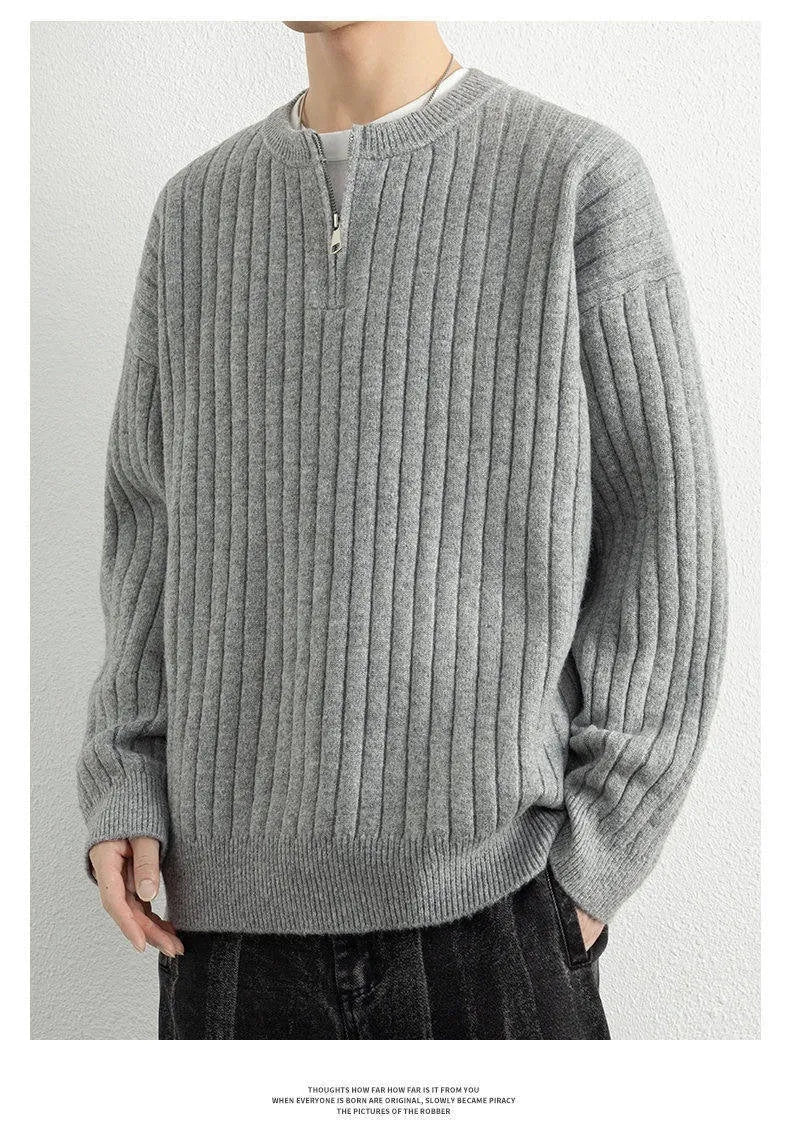 Men's grey half-zip loose knitted pullover sweater with textured fabric on a solid colour background.