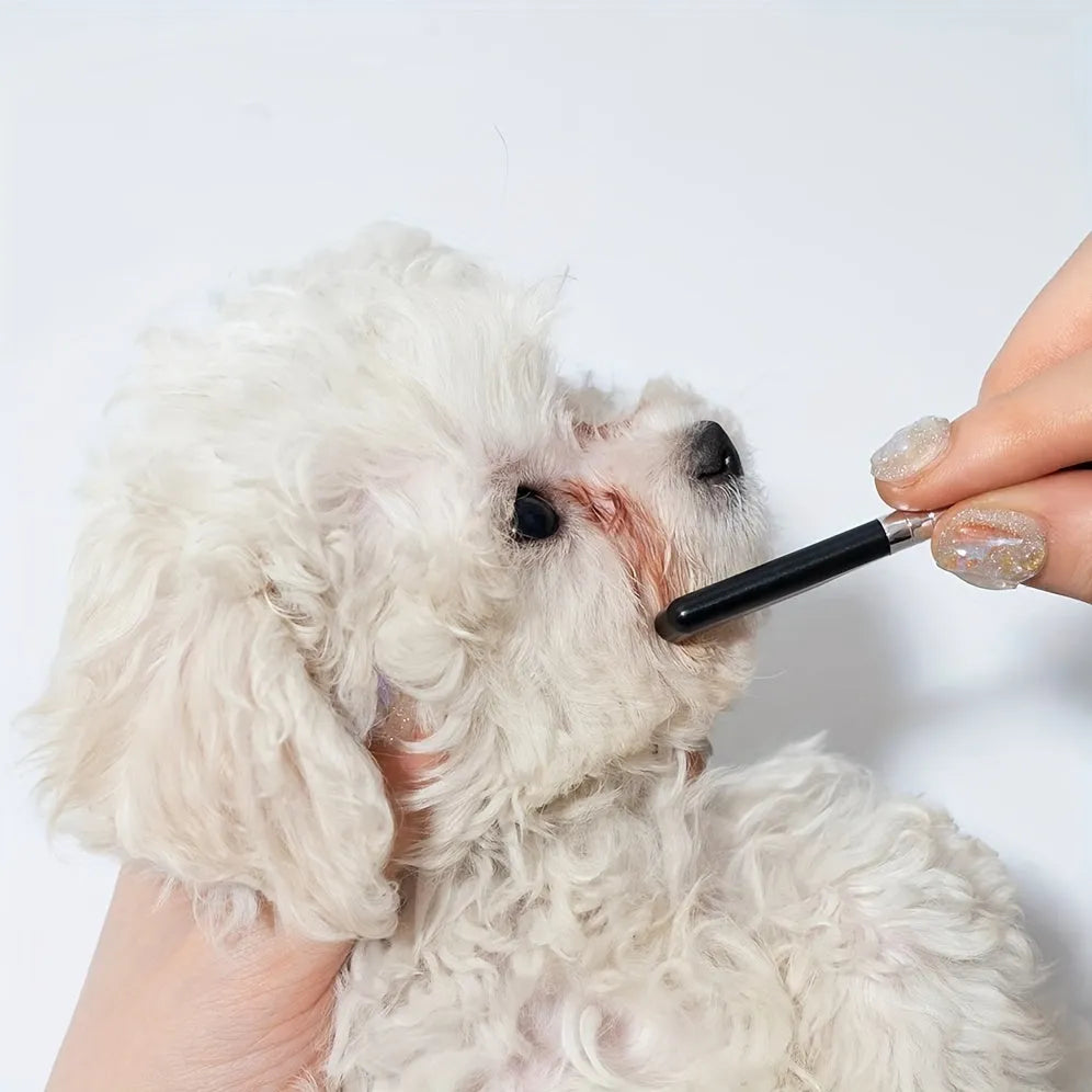 Black pet grooming brush with soft silicone bristles for gentle eye cleaning on dogs and cats