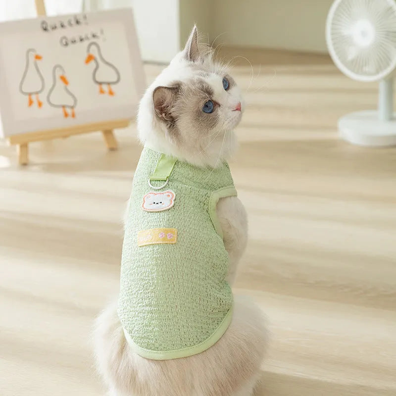 Green knitted cat clothing with a bear patch and breathable hollowed-out design on a cat model.