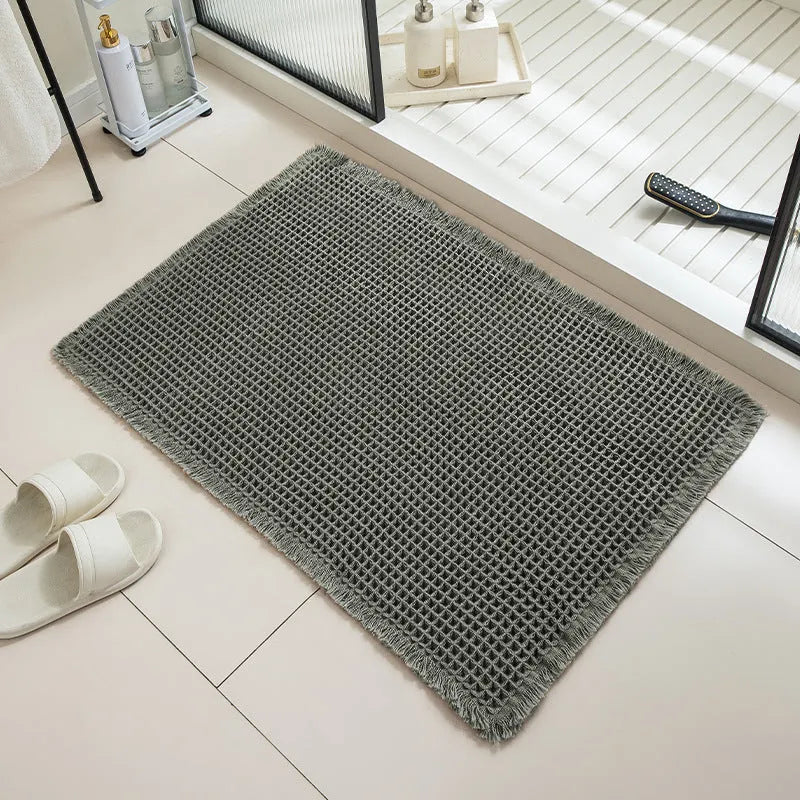 Square checkered pattern bathroom carpet on tiled floor in light grey colour.