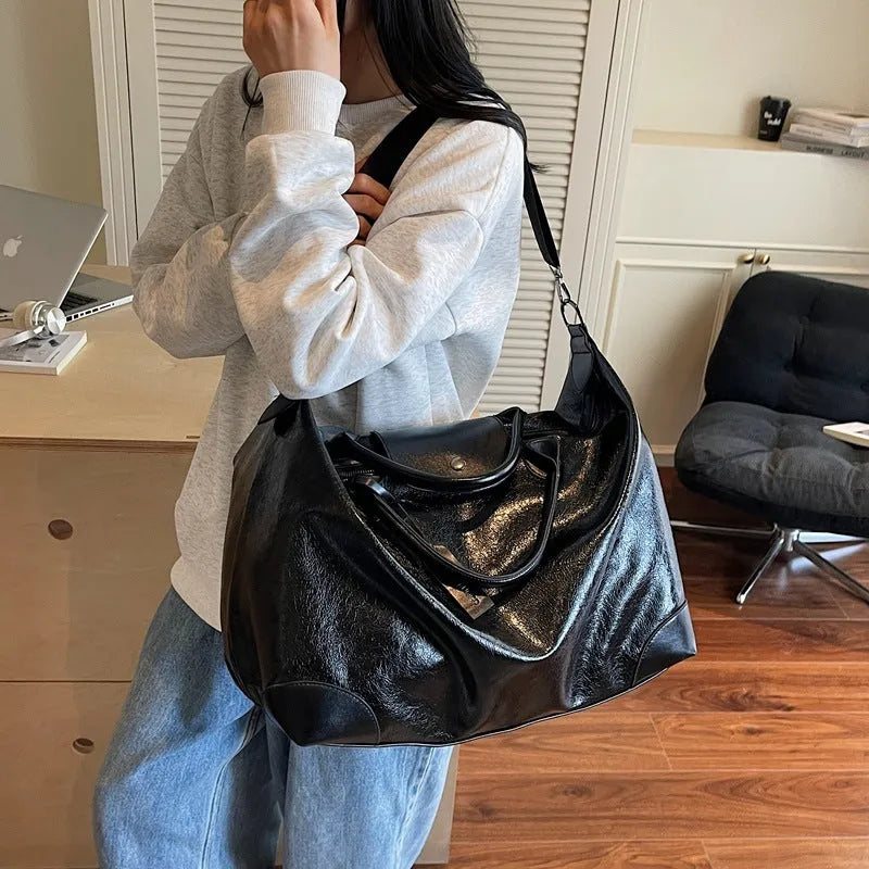 Large hand-carrying travel bag for women in black, capacity 36-55L, made from PU material with polyester lining