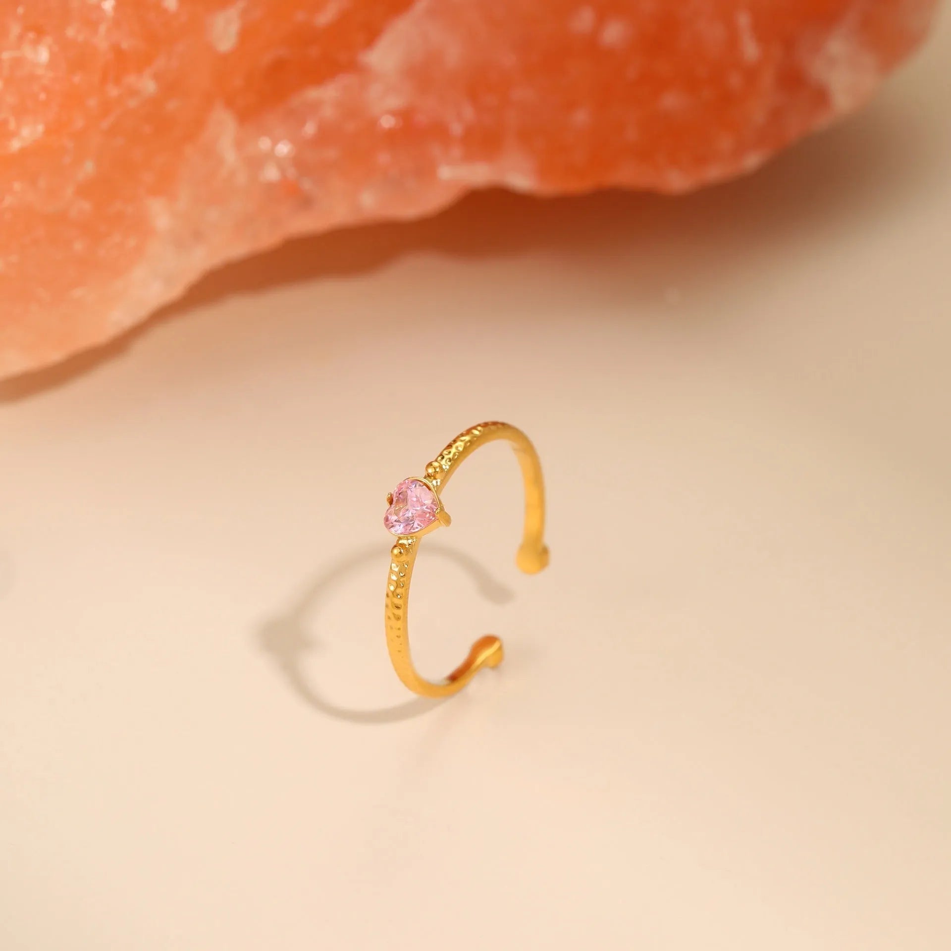 Open ended stainless steel ring with a geometric zirconium love heart inlay in green, pink, or white.