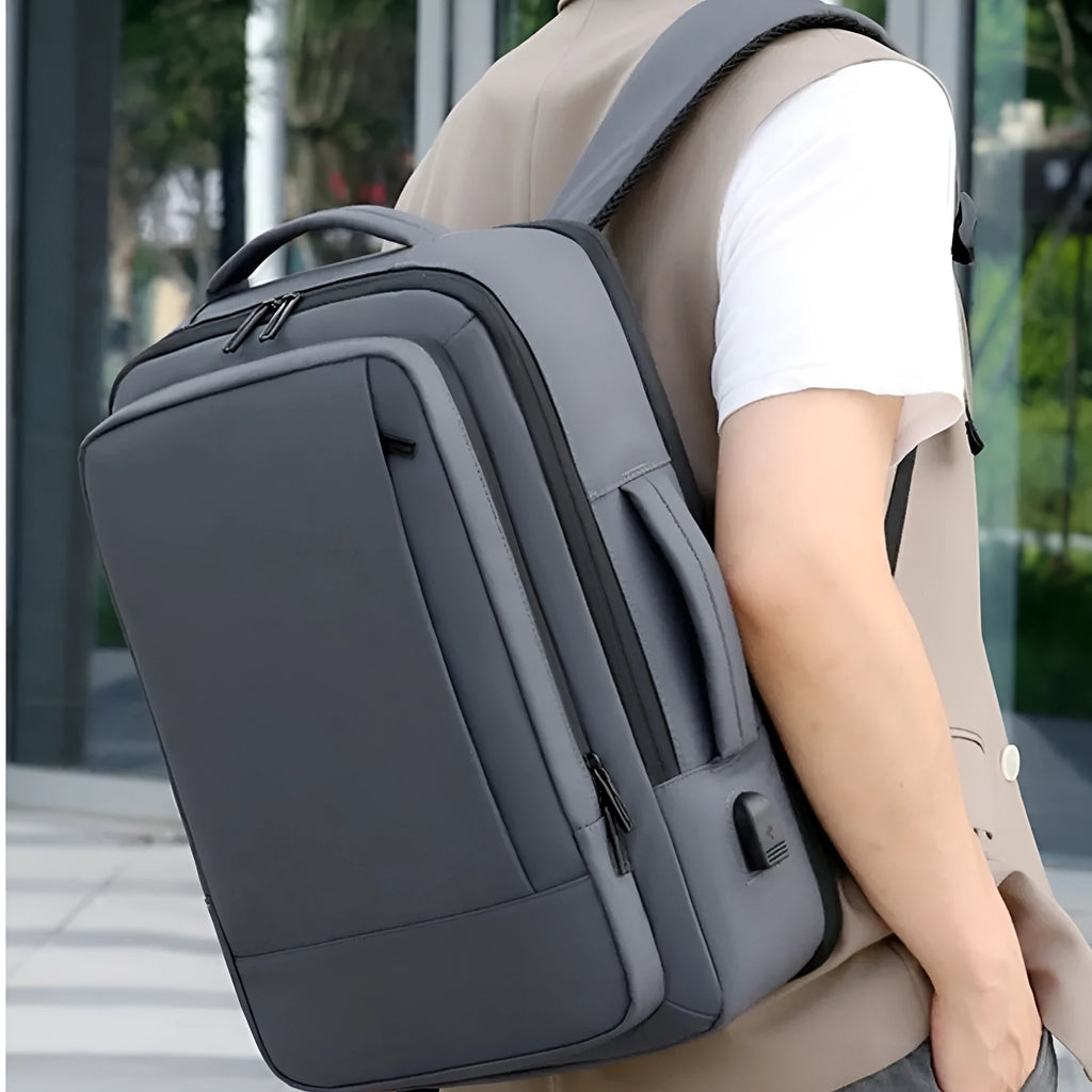 Men's large capacity waterproof backpack in black or grey with curved shoulder strap for business travel