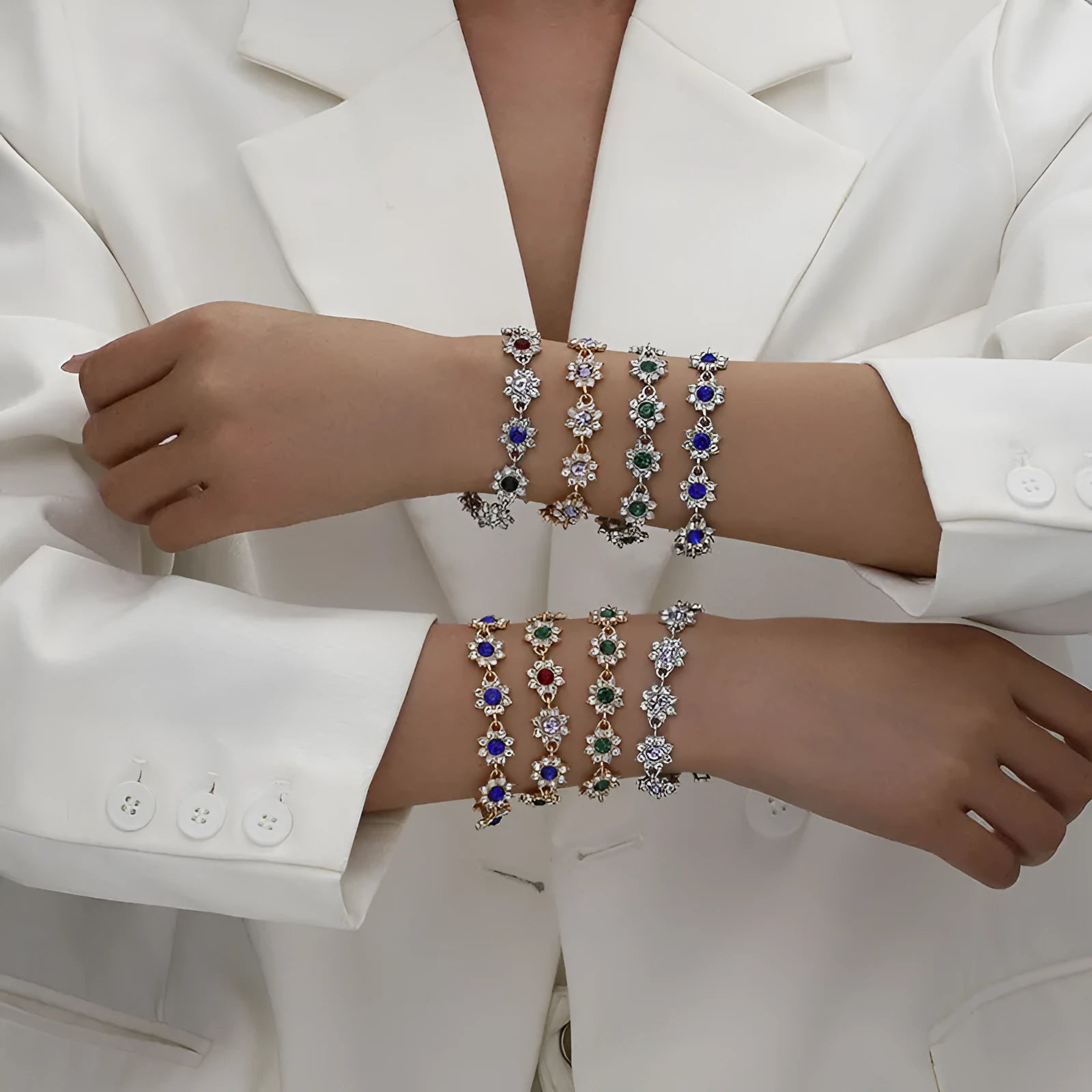 Electroplated zinc alloy bracelet with flower-shaped coloured gems in gold or silver tone.