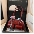Pillow-shaped PU leather women's handbag in black with ribbon pendant and double shoulder strap