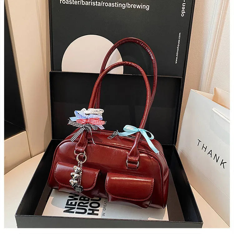 Pillow-shaped PU leather women's handbag in black with ribbon pendant and double shoulder strap