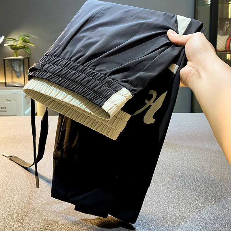 Men's solid black ultra-thin ice silk cotton trousers with a cropped leg and elasticated ankle band.