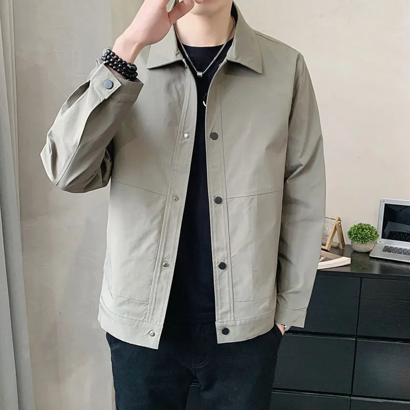 A man wearing a thin, single-layer Korean-style jacket in light grey, suitable for spring or autumn.