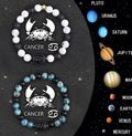 Two natural stone beaded bracelets with zodiac sign charms on a wooden surface