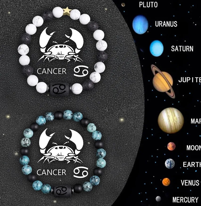 Two natural stone beaded bracelets with zodiac sign charms on a wooden surface