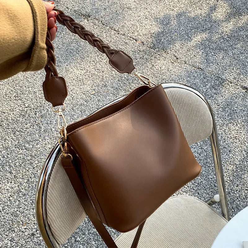 Retro woven PU bucket bag in khaki colour with crossbody strap shown in model shot