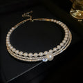 Curved round geometric silver necklace resting on a collarbone
