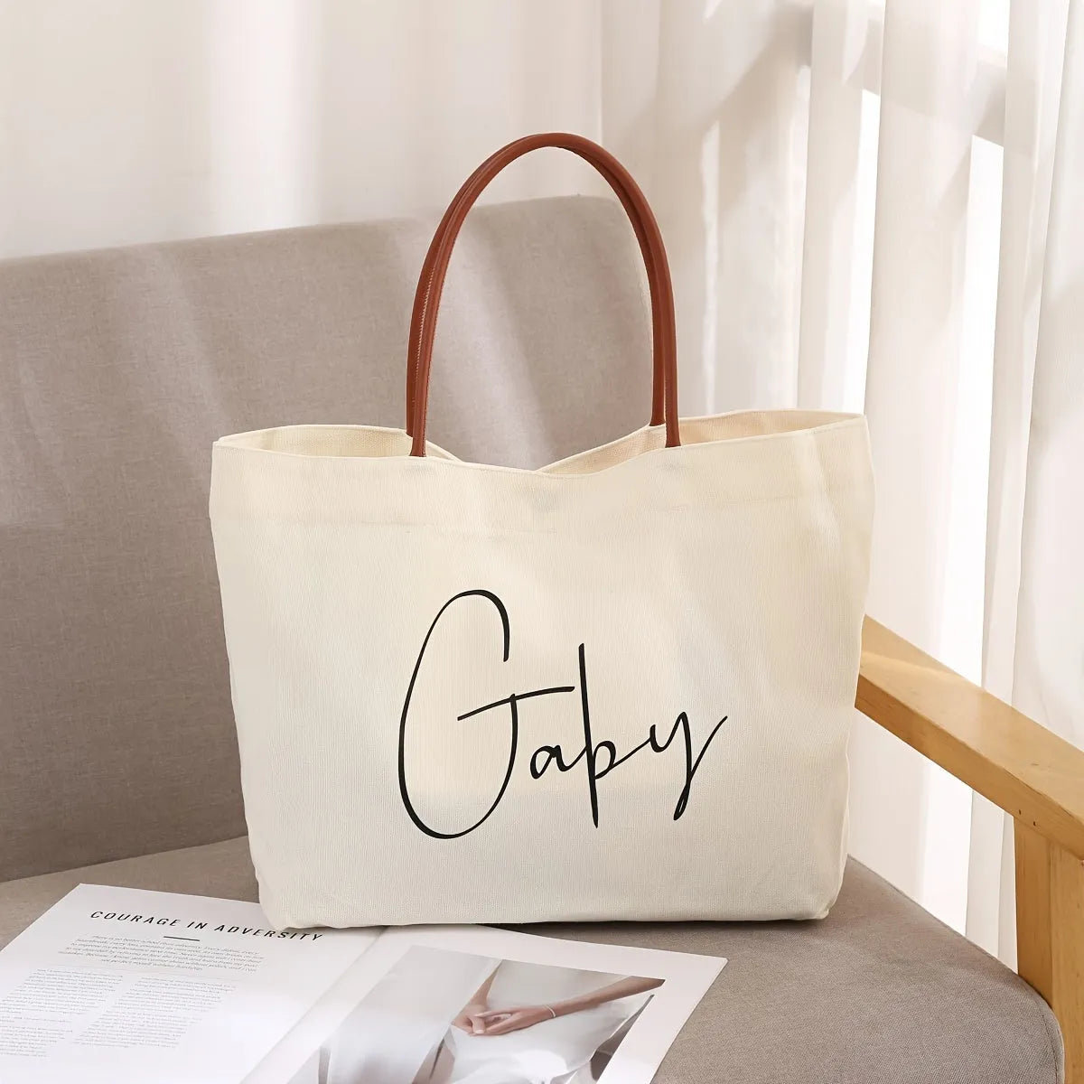 Beige white canvas tote bag with cotton handles, showing interior patch pocket and exterior zipper pocket.