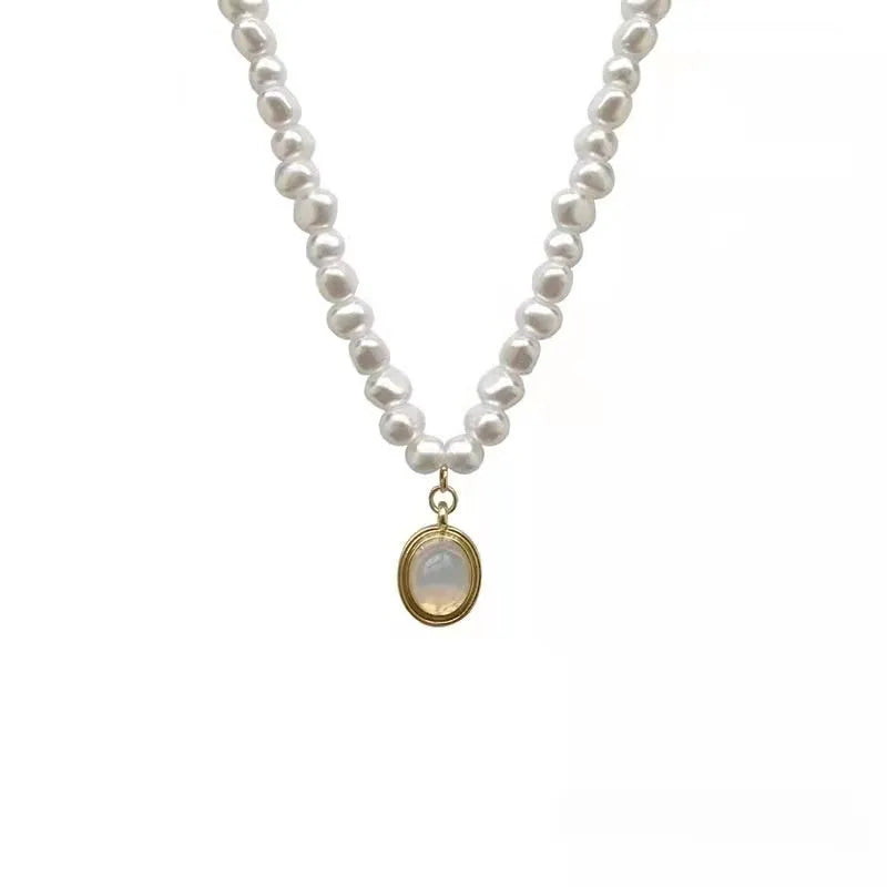 Adjustable vintage pearl necklace with geometric design on a grey background.