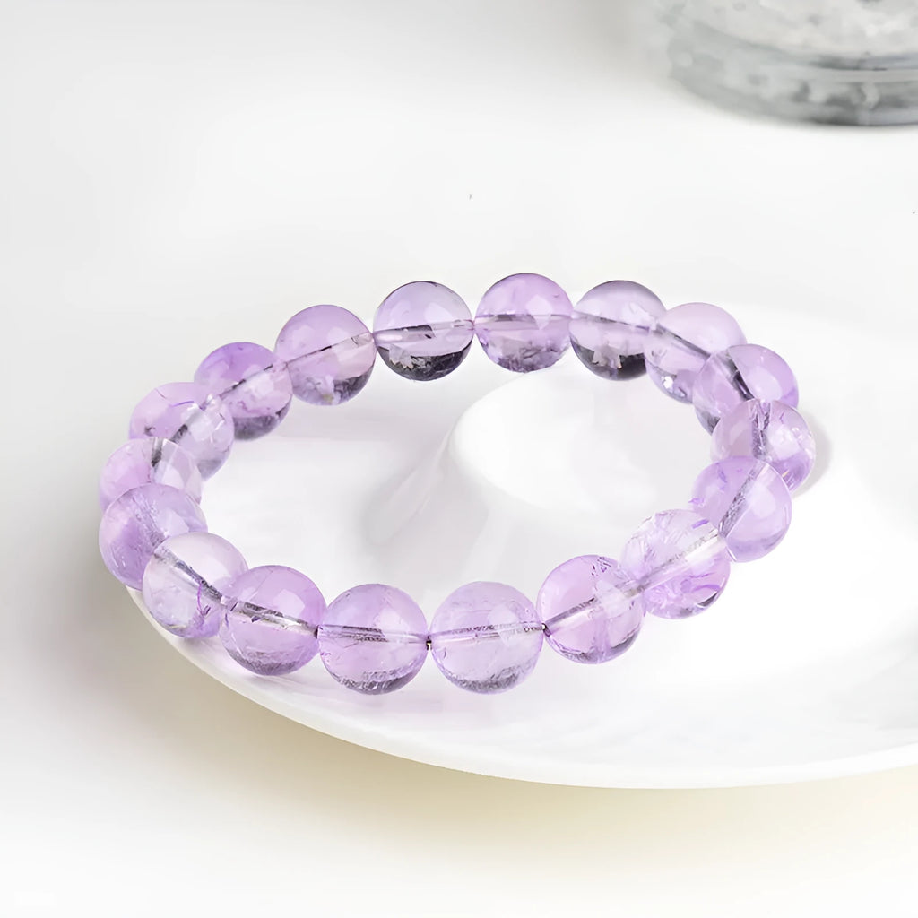 Light purple amethyst crystal bracelet with round beads and water ripple design on a wrist.