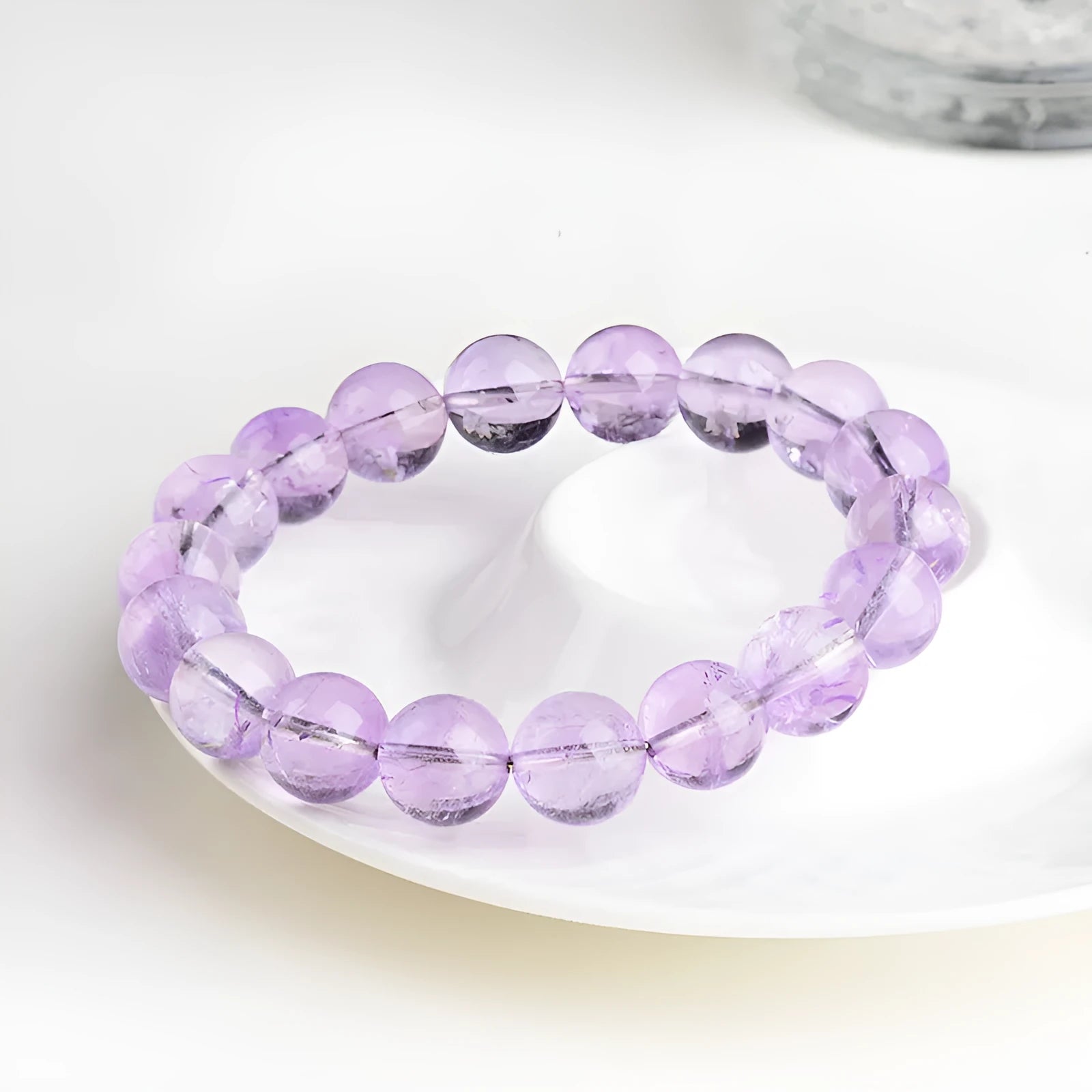 Light purple amethyst crystal bracelet with round beads and water ripple design on a wrist.