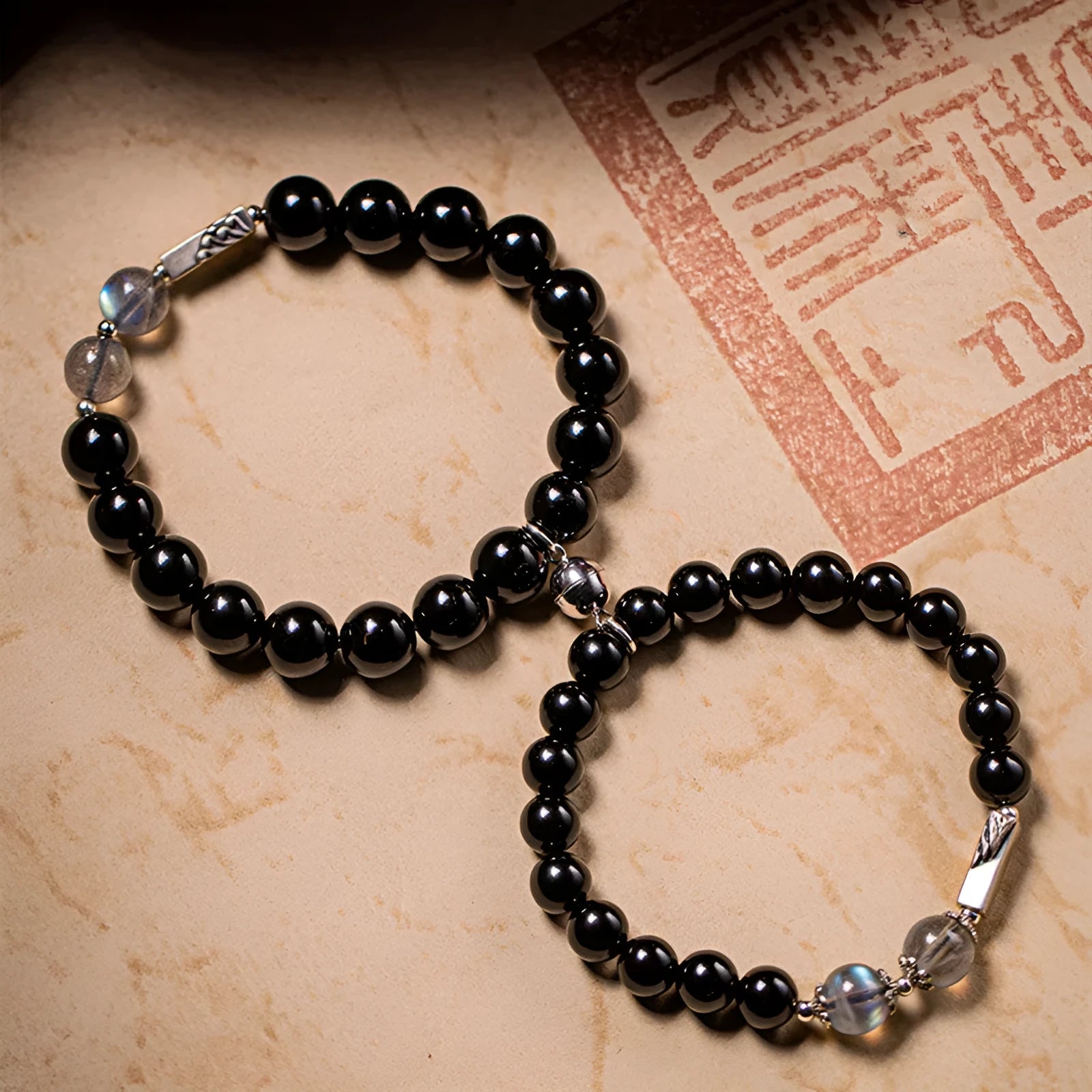 Obsidian Buddha beads couple bracelet set showing 10mm men's and 8mm women's Tibetan style bracelets