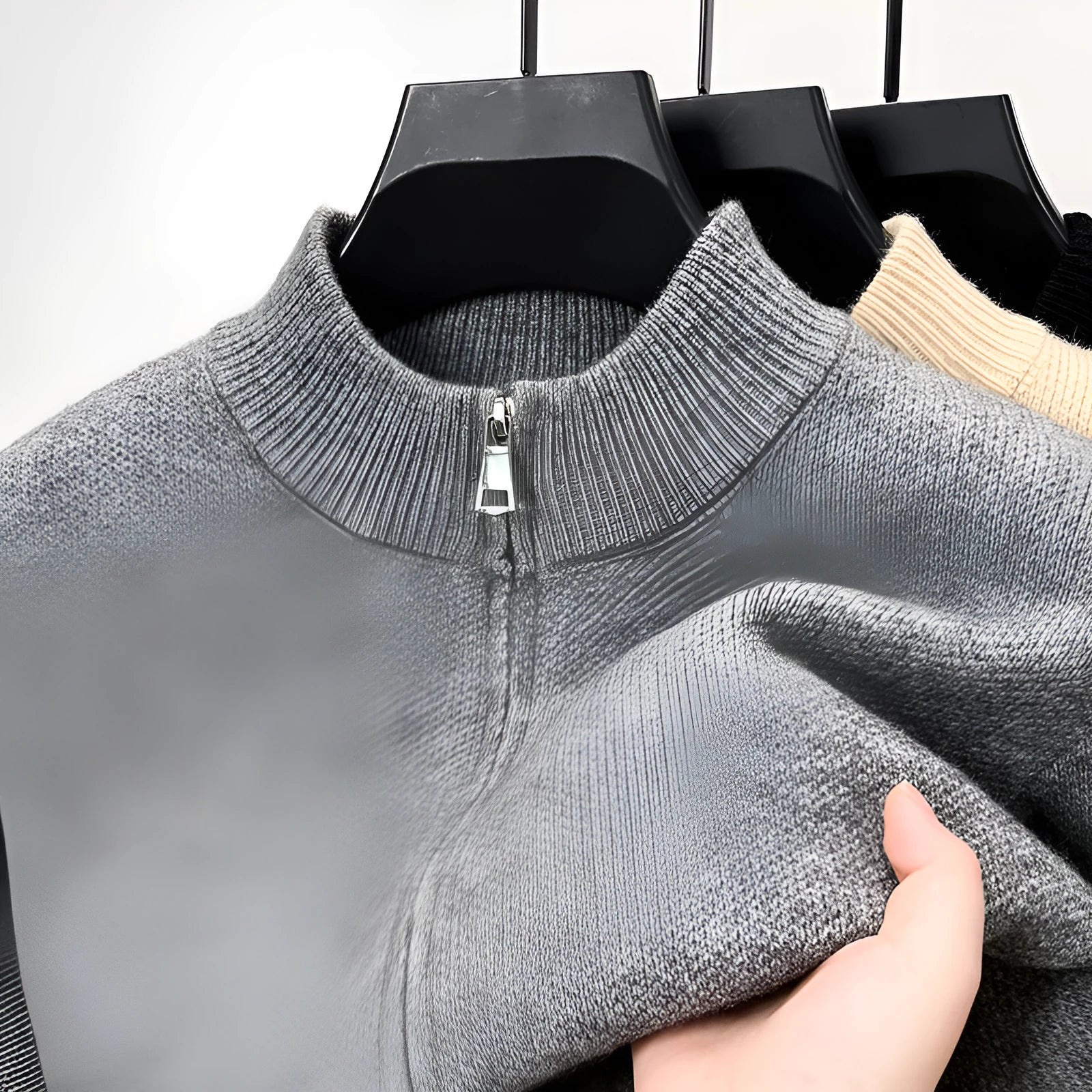Man wearing a beige stand collar knitted zip cardigan in a loose fit.