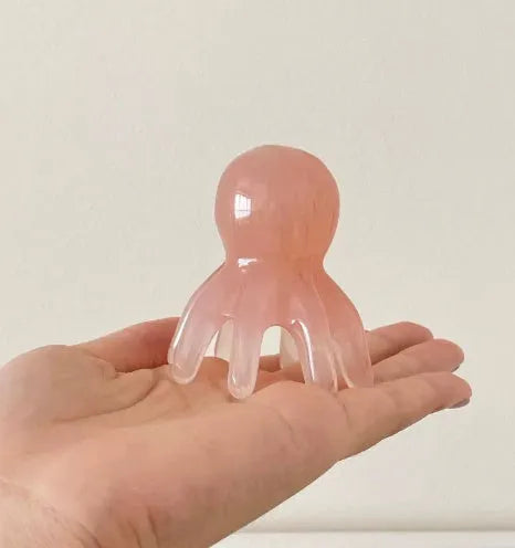 Pink natural resin octopus-shaped massage comb for periocular meridian health massage.