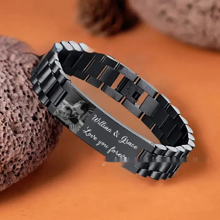 Men's titanium steel bracelet with curved heart shape and black lettering in a gift box.