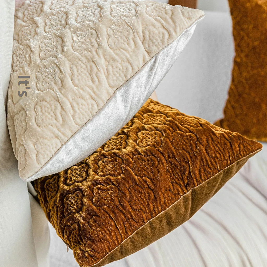 Brown gold antique quilted square cushion pillow on a sofa next to a green waist pillow.
