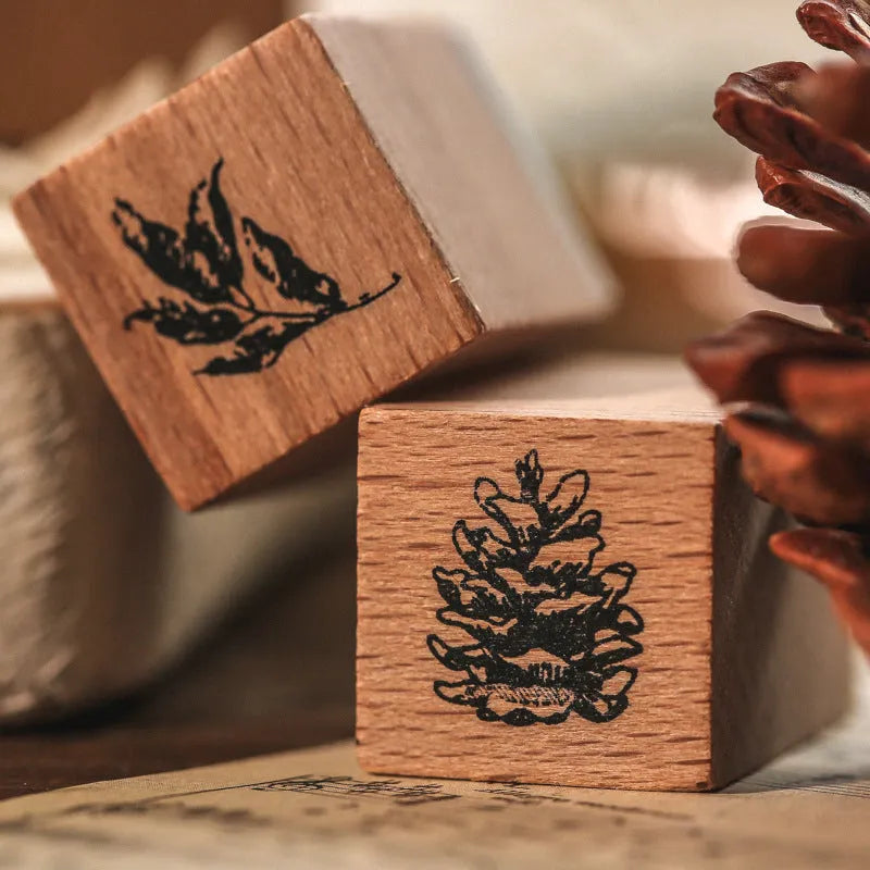 Wooden decorative stamp set with seven hand-carved botanical or celestial designs for paper crafts