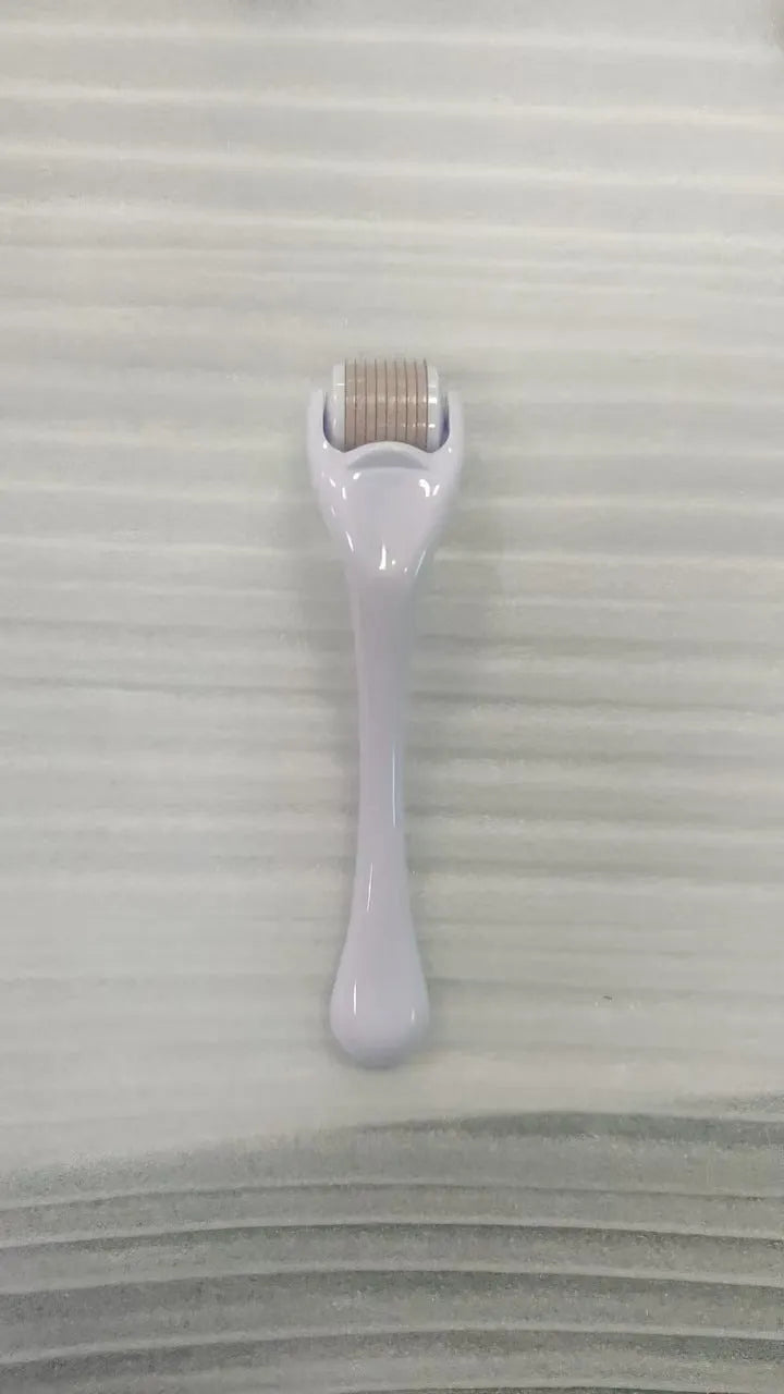 Mechanical micro needle roller device with coloured handle and wheel on a white background