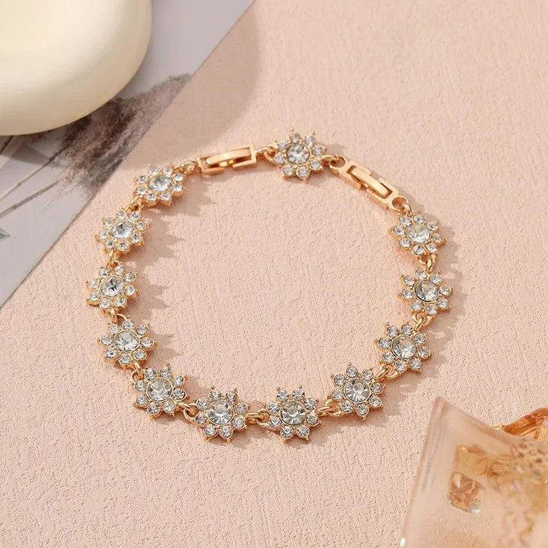 Electroplated zinc alloy bracelet with flower-shaped coloured gems in gold or silver tone.